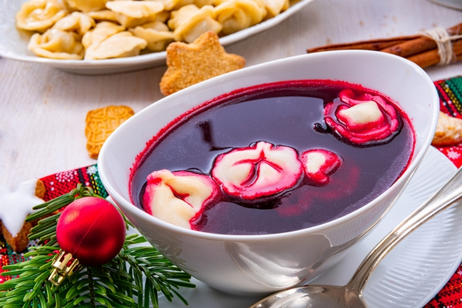 Festive bowl of Polish red borscht with dumplings, served during Christmas, showcasing Poland's traditional holiday cuisine with a vibrant presentation.